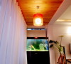 客厅一角上的鱼缸、杉木吊顶、红色的垂灯，丰富了生活又充满了情趣