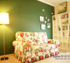 房的一个角落，绿色的背景墙加上碎花的布艺