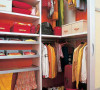 步入式衣橱内可以收纳很多衣物用品，充分利用了储物盒子和挂钩等物件