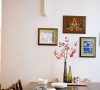 实木的餐桌椅温馨而自然，墙上装饰一些画