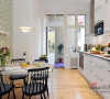 镶板门和异型厨房碗柜形成鲜明对比的白色时尚的厨房