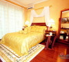 主卧金色的床盖和金色的墙纸相互搭配，既温