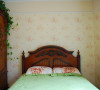 卧室碎花壁纸配上原木色的床、衣柜，衣柜上设计的绿色植物，增添了一抹绿色，象征着大自然的生机与活力。