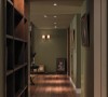 设计师在廊道增加了书柜的功能，深咖色的木皮质感丰富了空间神采，也让原本单纯的过道表现层次与场域表情。