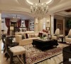 客厅中最引人注目的是正中间有着十几平米面积的针织地毯。繁复的花式与颜色代表着古典主义的奢华，而简单的家具、吊灯和天花板则说明业主对生活的品味以及设计师的专注。