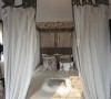 典型欧陆情结的金色富贵纹饰壁纸附于墙上，搭配做旧风格的装饰画和素色睡床流露出一种温柔地高贵。