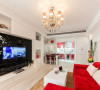 大红色转角沙发，是整个客厅的大亮点，白色靠垫、白色的茶几、白色的电视柜，再搭配黑色的电视背景墙，三种绝配的颜色。唯美的简欧式水晶吊灯让整个客厅顿时生动起来