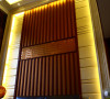 名雕丹迪设计--金地九珑璧别墅--新中式客厅沙发背景：木质条纹结合黄色软包装墙面，时尚而简约。