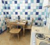 厨房与餐厅在一起，用了浅色的地砖斜铺以及大理石材质的波打线以及蓝色瓷砖的踢脚线和浅色系的墙砖，餐厅用了木制的三人餐桌，体现出了地中海的风格。