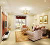 厅的整体感给人以舒适而又温馨，粉色细碎花的布艺沙发让人心情平缓舒畅，各种金色边框和金黄色地毯增添了点奢华