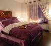 主卧室浅紫色的轻纱柔帐和紫色的床罩在灯光的映衬下让整个居室浪漫温馨，布艺材质的窗帘和深咖啡色系的地板衬托出卧榻的柔软和宽大。卧室有如梦镜般的恬静。