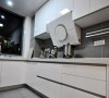 白色烤瓷橱柜搭配灰色瓷砖，展露出低调的时尚风范。