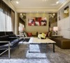 设计师以灯光、材质、线面铺陈客厅，沙发背墙构置了茶镜与壁灯，赋予新古典的对称美感。