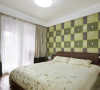 青翠是这个卧室的主题色，最吸引人的是墙纸，深度不同的绿色格子描绘着花草世界，形成强烈的对比，也让墙面充满立体感。与墙纸相配，床上四件套购买了绿草点缀的清新款式，十分赏心悦目。