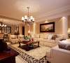 客厅整体突显出一种豪华大方的贵族气息，大面积的地毯搭配着造型优雅而舒适的美式沙发。温暖的色调，白色的灯光，更显家的温馨。
