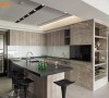 厨房中以仿板岩纹理台面加上木纹质感厨具，实现屋主梦想中的餐厨空间。