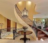 在楼梯交错的空间，利用一个铁艺吊灯、圆桌和花束，来丰富空间的层次。