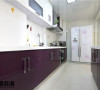 这套厨房的装置可以说相当的时尚前卫，“二”字型的厨柜充实了厨房的空间
厨柜的台面和吊柜同样采取了白色的基调。不过暗红色烤漆的门板陡然打破了这份沉静。白底紫花的双开门冰箱则在两者中起到了过度作用。