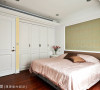 主卧房色调温暖且稳重大方，床头使用图腾壁纸弥漫优雅的气质，并围塑一贯的设计主轴。