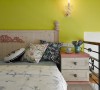 同样选择以柠檬黄跳色，呼应了厅区背墙的彩度延伸。而在床头柜与壁灯的配合之下，营造出更加完整的风格细节。