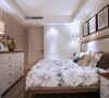 由于业主平时的衣物比较多，所以卧室在符合活动空间的基础上，增加了更多的储物空间。乳白色的衣柜与床头软包整体搭配自然朴素。