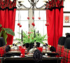 黑色的桌椅搭配红黑绿色经典苏格兰纹布艺，吊灯上的圣诞球演绎出的是传统而极具主题感的圣诞餐桌。饱和的红黑格纹醒目点缀其间，强化着空间的主题元素。