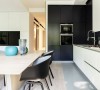 木质的餐桌，非常简约。黑色的椅子，和厨房的背景墙很好的融为一体。