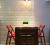 温润木质的餐桌椅，以鲜明的红作为跳色，再打上一盏工业风造型的壁灯，让空间增添丰富神情。