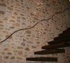 搭配流线型铁件把手，使用老木材质打造，以金属铁件镶嵌于石材壁面，每个悬空梯段皆独立互不连接。朴质与现代，看似冲突却和谐。