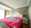 房间内家具不多，淡绿色的床跟单色的墙纸显得房间内十分淡雅舒适。