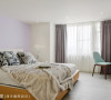 床头墙漆上粉紫色，搭配户外引入的自然光，让卧室呈现宽敞明亮之感。