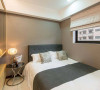 次卧空间稍小，设计师以饭店式功能规划，安定的选色与屋高比例，让空间沉稳而宁静。