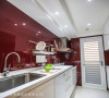 为了搭配屋主购置的酒红色冰箱，厨房壁面运用酒红色玻璃烤漆，清亮的设计带来一致性的视觉效果。