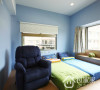 蓝色的儿童房简洁明亮又充满童趣，深蓝色单人沙发专为爸爸定制，便于睡前给孩子们讲故事。