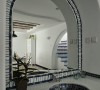 卫生间前洗漱台镜子也做成拱门形状，白蓝碎石桩设计凸显细节。