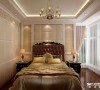 米黄色软包的床头背景墙干净简洁，配合左右对称的床头柜背景造型，透露着温暖优雅的气质。