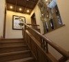 复式家居中总少不了连接上下层的楼梯，这个朴素的木质楼梯设计，虽没有复杂的点缀和装饰，却有着颇具古典韵味的典型气质。吊顶上的射灯按照一定的形状排列布置，营造出幽远意境。墙上的水墨画让空间有了艺术气息。