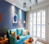 孔雀蓝色的布艺沙发在原木家具和白色窗帘的衬托下无比清新。