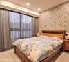 床头壁面以黑白色系的花草图案壁纸做铺陈，烘托出床头柜的木色质感。