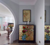 玄关处一个手绘中国画的装饰柜和装饰画相映成趣。
