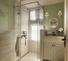 浅色木纹砖与草绿色墙面的色系搭配，营造清爽舒适的沐浴空间。