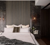 床头主墙使用大理石来增添恢弘气韵，并搭配线条优美的编织地毯，营造精品旅馆的感觉。