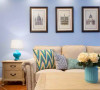 几何纹理抱枕、建筑挂画、蓝色花瓶和台灯让空间表情更加丰富。