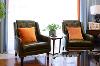 客厅：深色沙发与橙色抱枕，给人眼前一亮的感觉，彼此交相呼应，客厅里放置绿植、时尚有品位的艺术品，彰显其气质和视觉上的美感。