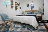 改造后，卧室运用了主题色蓝色来使沉郁的空间变的舒缓、开阔。地毯使用了几何图形的花纹，床、凳子、背景墙、颜色的互补搭配，使整个空间清新明亮