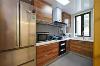 木纹饰面板的橱柜与灰色瓷砖搭配，使厨房看起来温馨、健康。