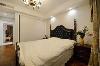 与客厅色调相同的深蓝色皮质大床显得高贵、典雅，搭配纯洁的白色打造放松的睡眠环境。
