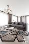客厅运用几何图形地毯与灰度沙发的搭配，在视觉上具有下沉的作用，提升了整体空间的格调品味。