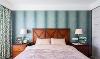 主卧选用灰绿色调，壁纸和窗帘相互呼应，搭配咖色实木美式床