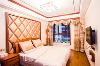 卧室木质的大床，雕刻精美的镂花窗格，加入了时尚流行元素，床头背景墙的菱格软包都充满了中国古典的诗情画意。